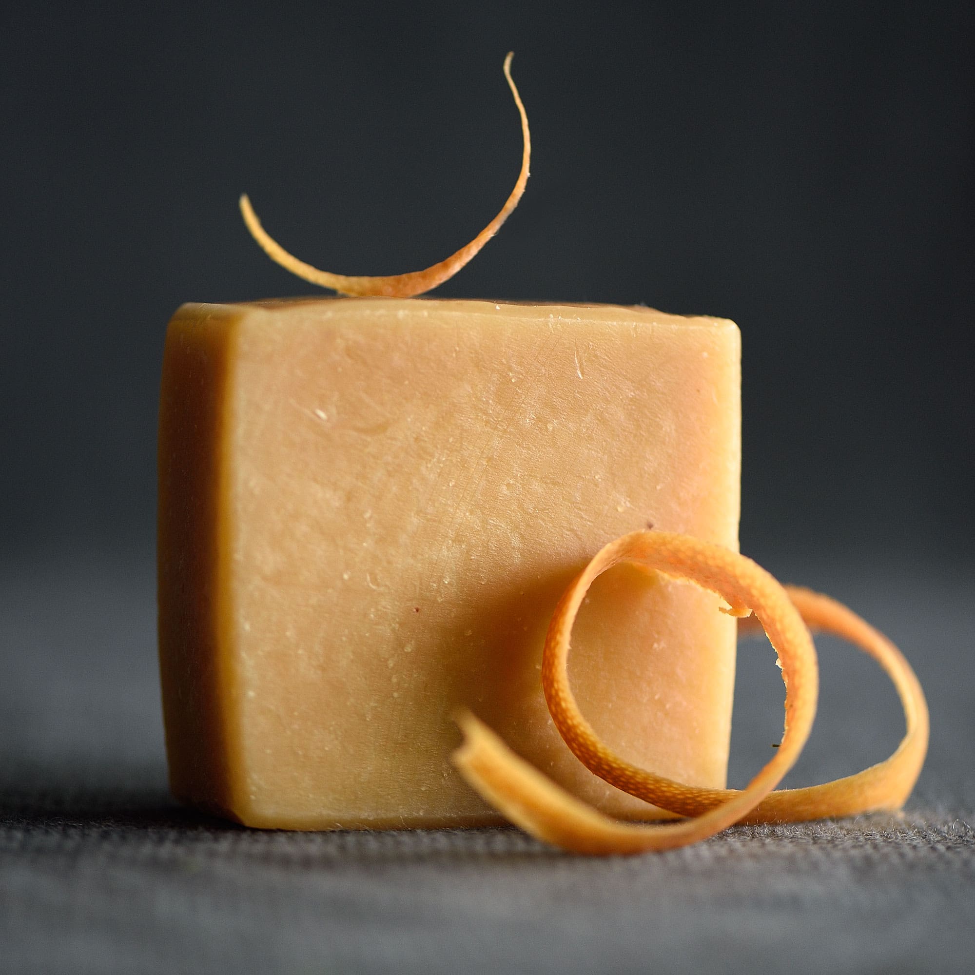 Gentle face soap bar displayed with fresh grapefruit peel